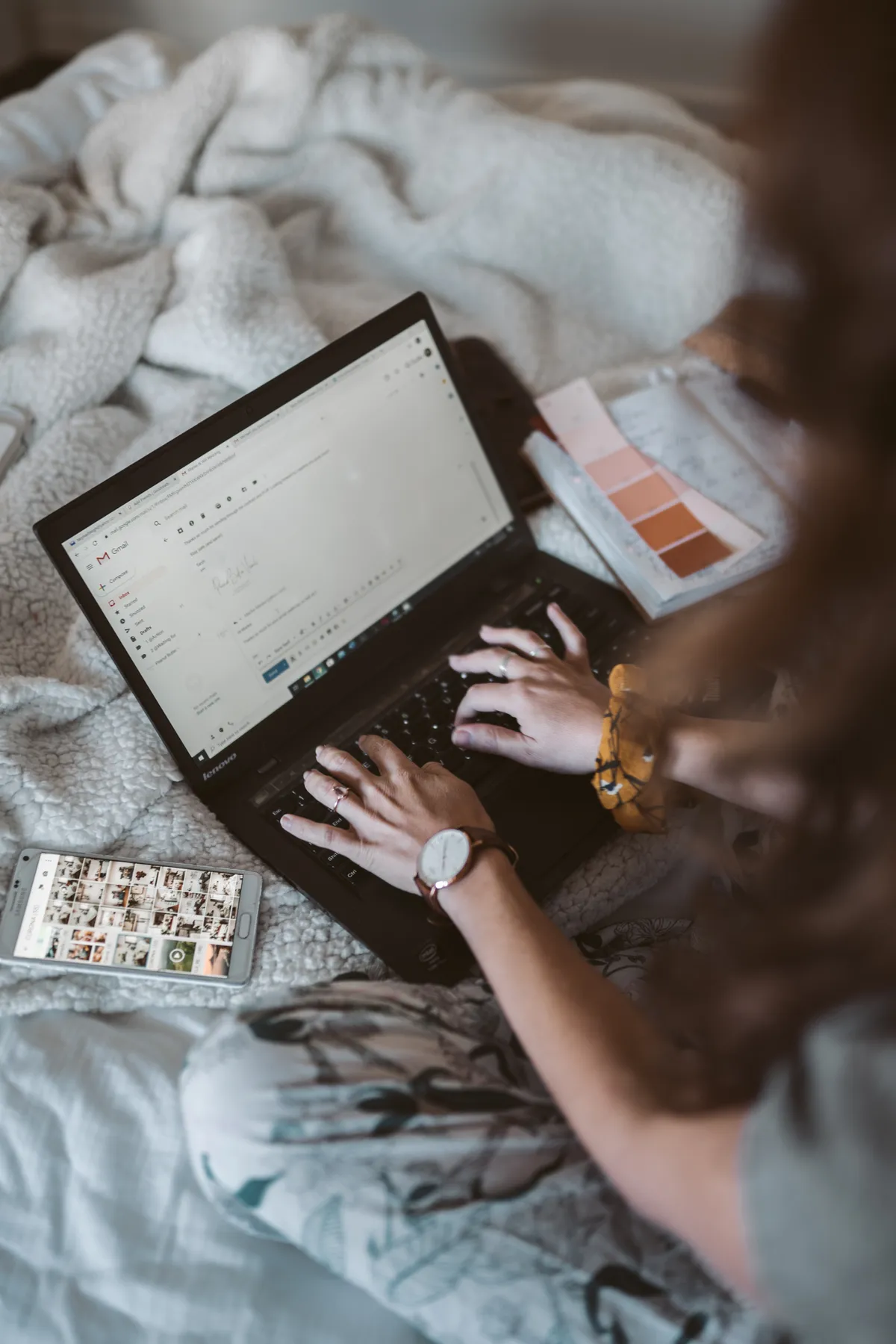 A woman reading an email in Gmail on her laptop at home.